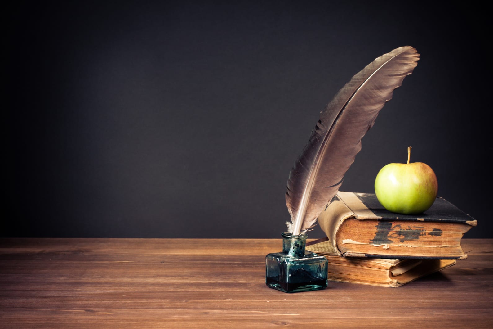 Feather pen and book placed on a table