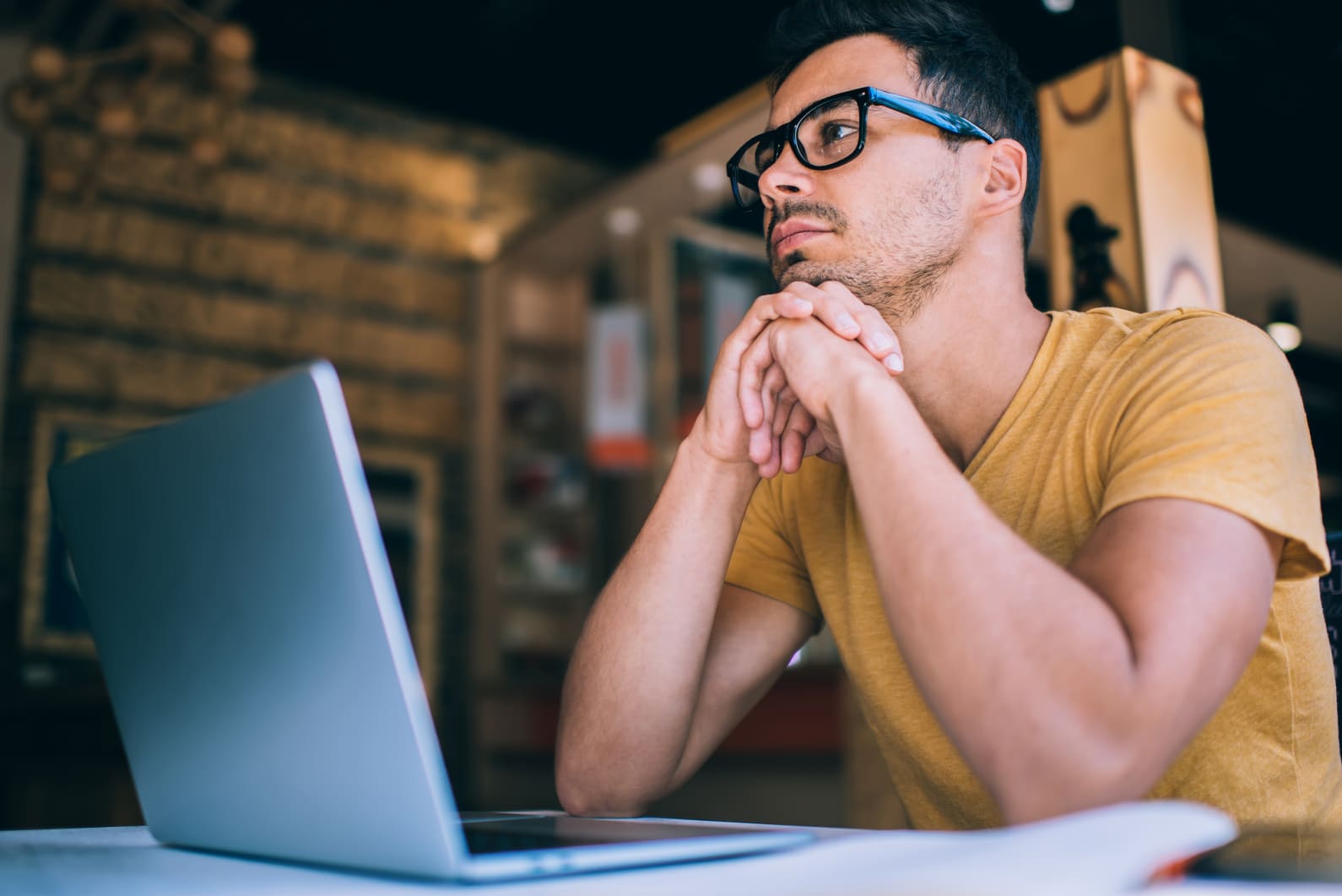 Student sitting looking at an assessment on a laptop