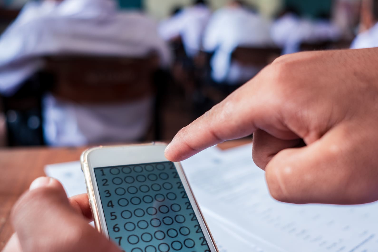 Person pointing at an assessment on a phone screen.