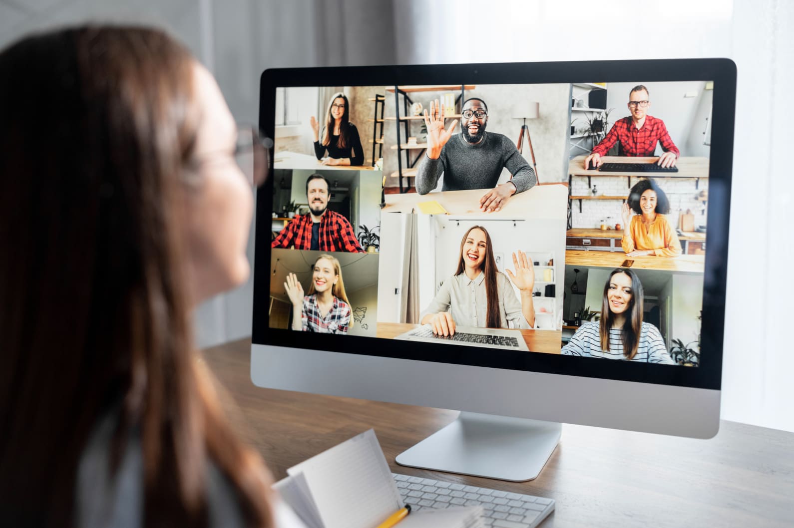 Woman looking at a computer screen - the computer screen is displaying people's faces