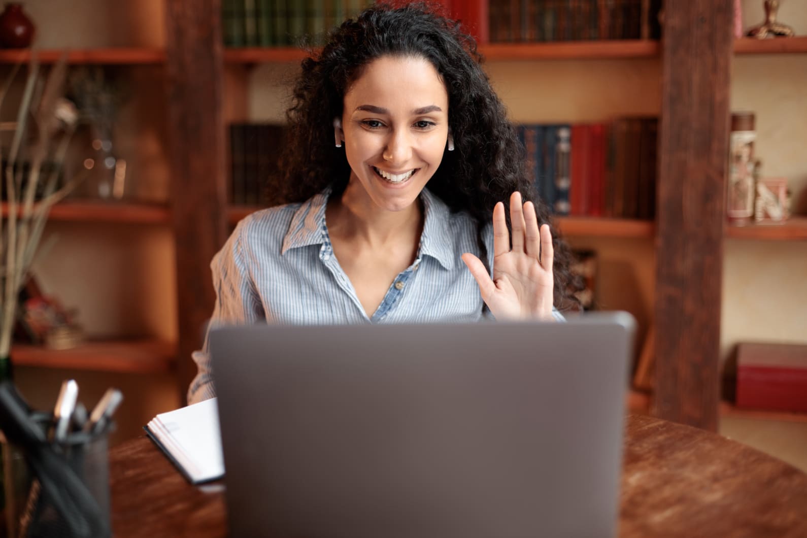 woman behind laptop grading papers and happy