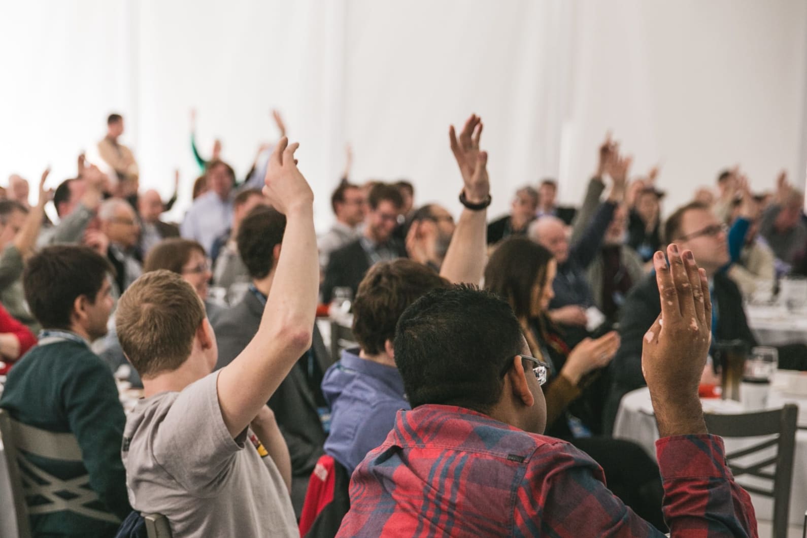 Students have hands raised in class