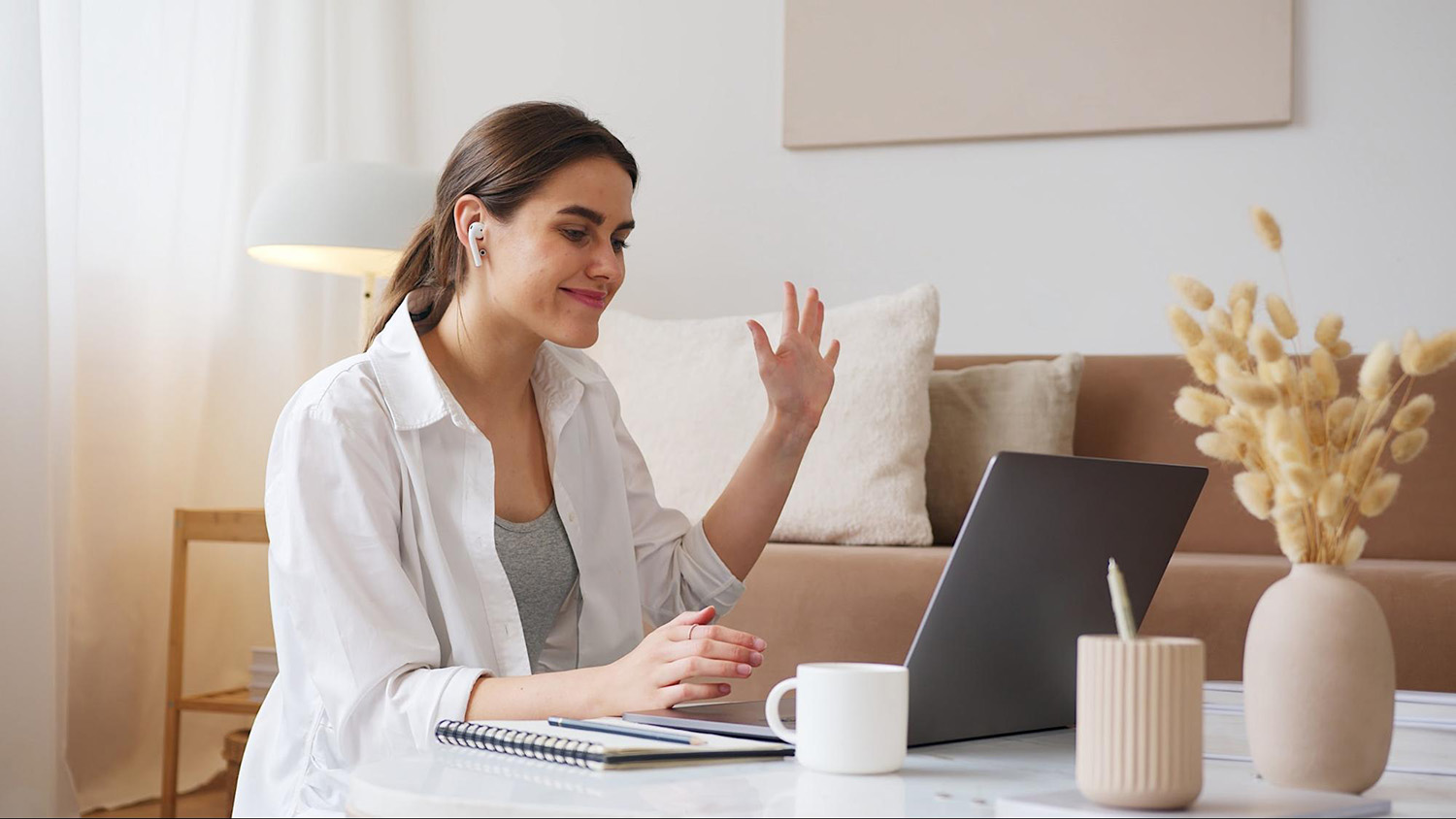 Student smiling and waving in a video call