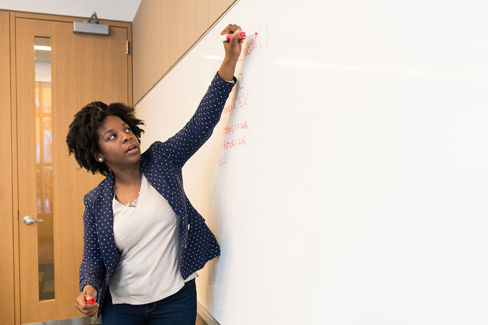 Teacher writing on a whiteboard