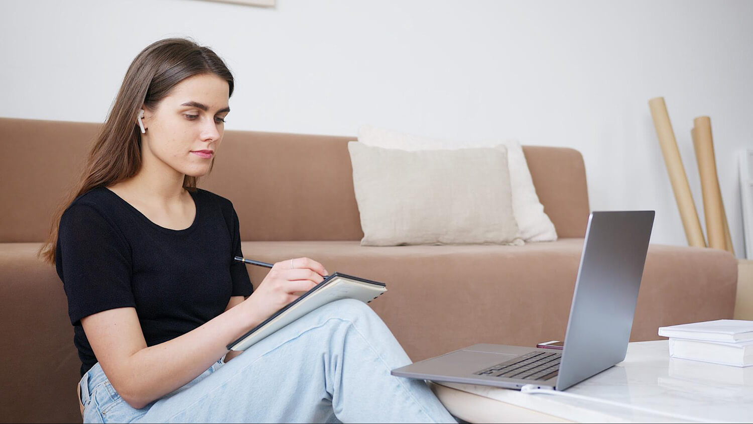 Student studying with a notebook and laptop