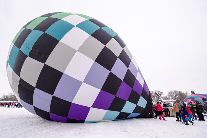 Photo of inflated air balloon on the ground. 