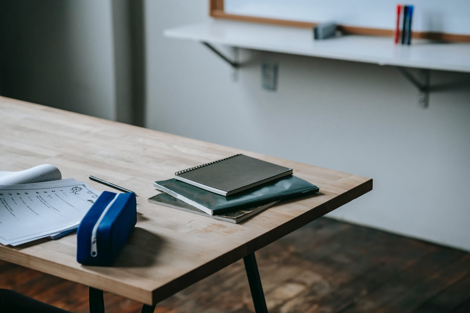 Books and a pencil case on a teacher's desk