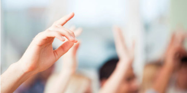 Students hands being raised in classroom.