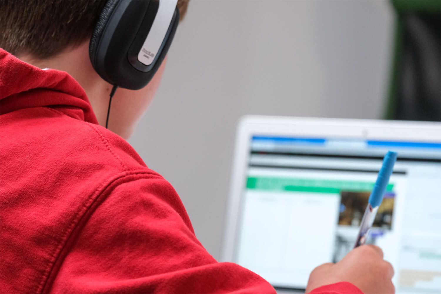 student wearing headphones and completing an assessment on a laptop