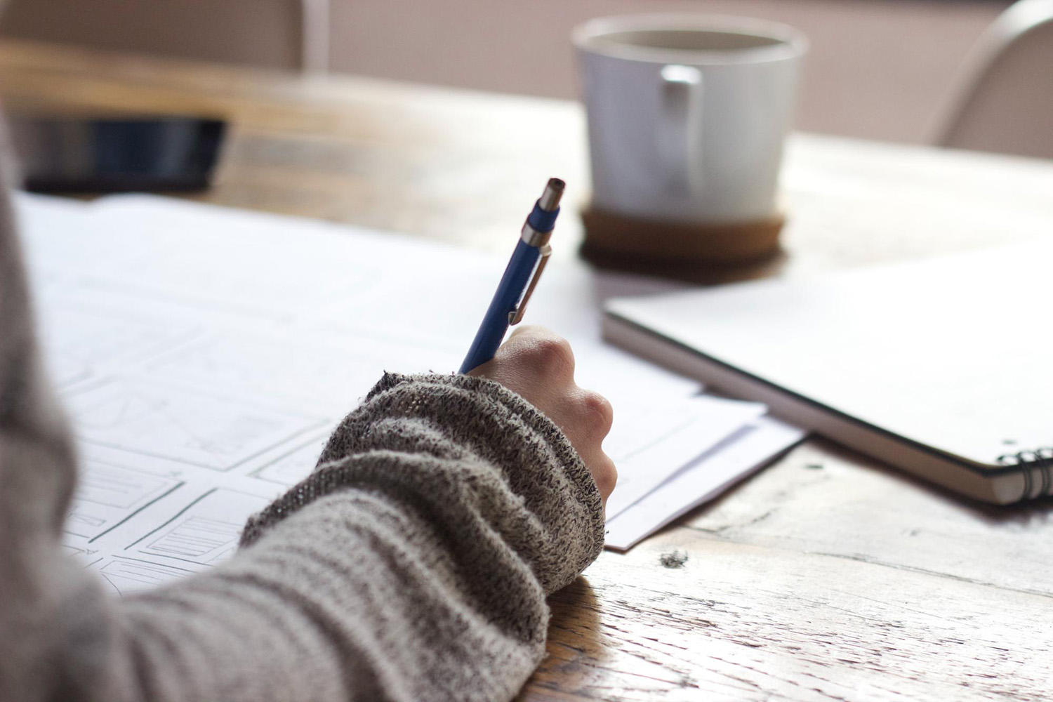 A student writing at a desk