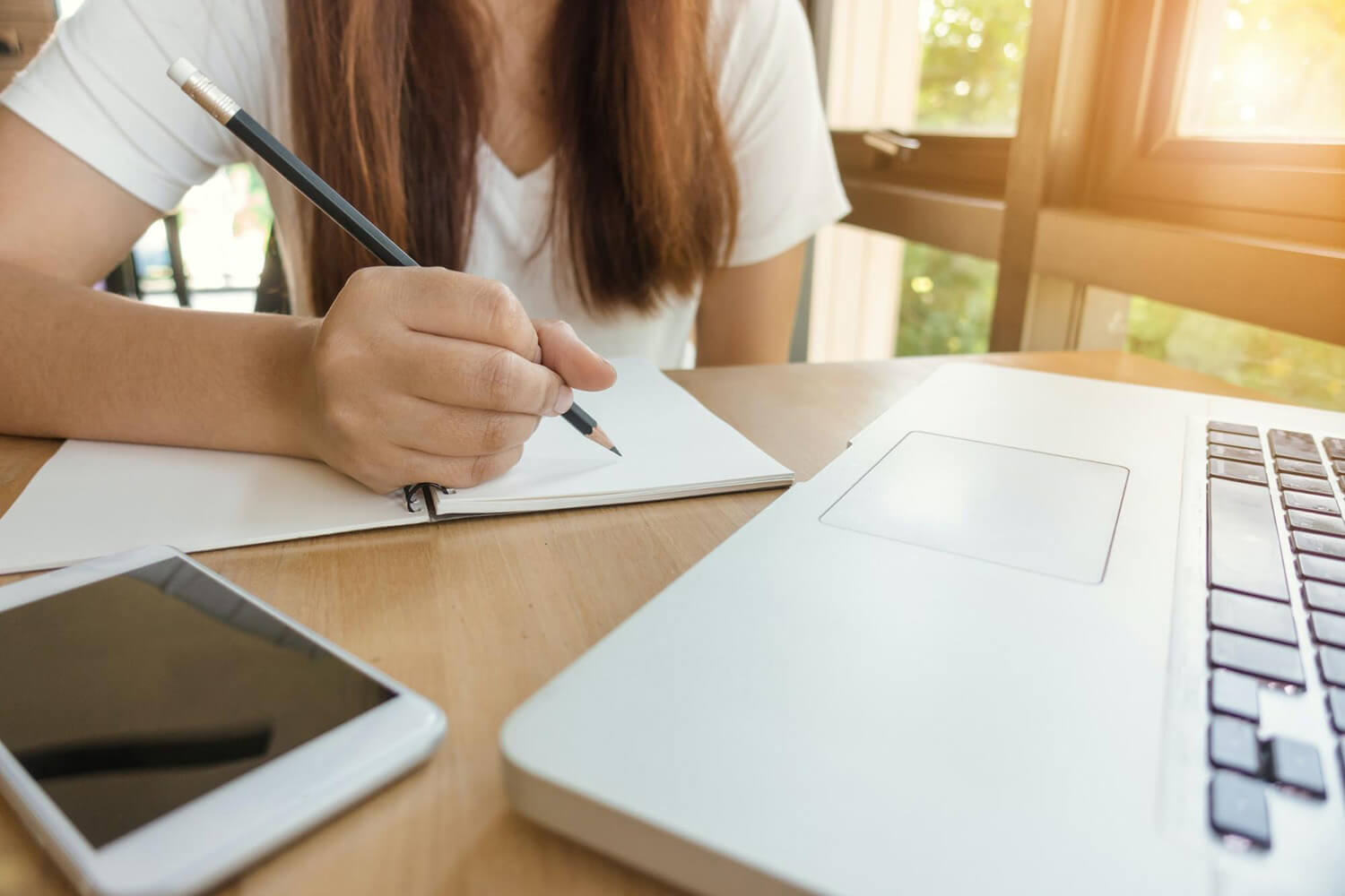 Student studying with a notebook and laptop